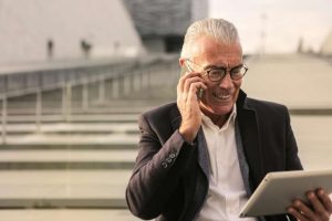 Man who is looking up Elderly Oral Health Care on his tablet to get a dentist appointment for his 70 year old wife.